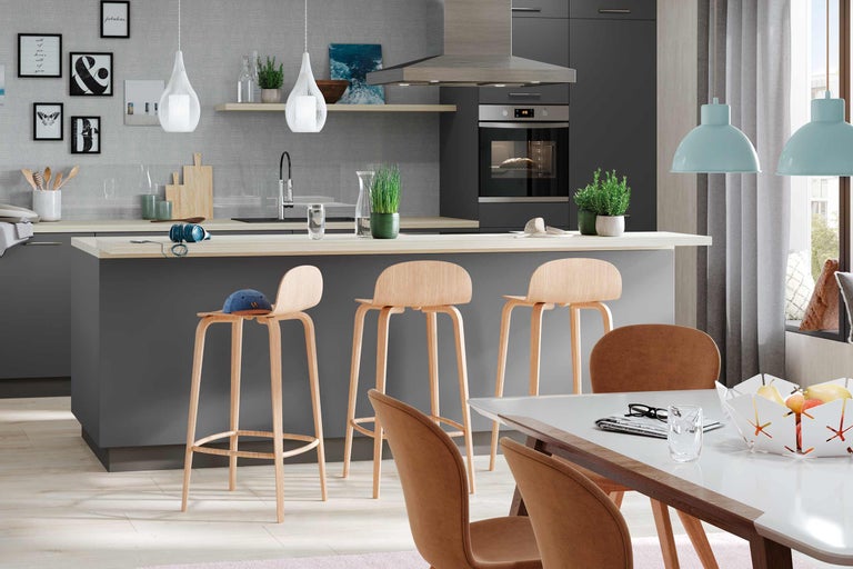 Cuisine claire avec tabourets de bar, table à manger et appareils modernes
