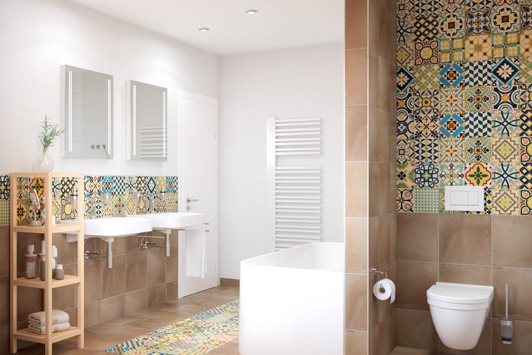 Helles Badezimmer mit Doppelwaschbecken, Badewanne, Toilette und farbenfrohen Fliesen