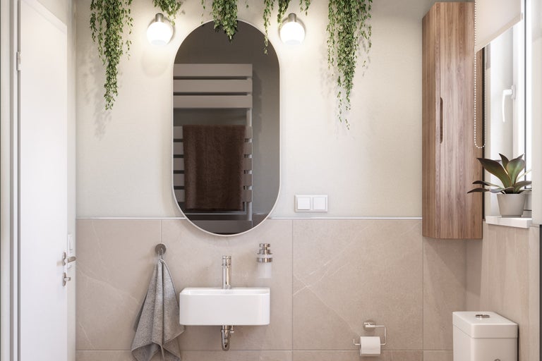 Salle de bains lumineuse avec miroir, lavabo, toilettes et armoire en bois