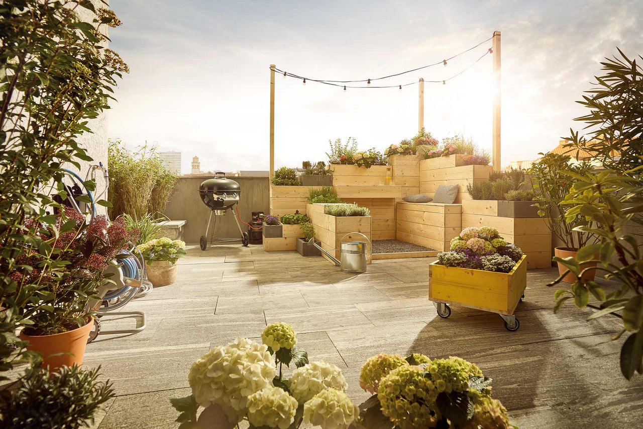 Terrasse sur le toit avec barbecue, plantes et construction en bois pour l'aménagement paysager