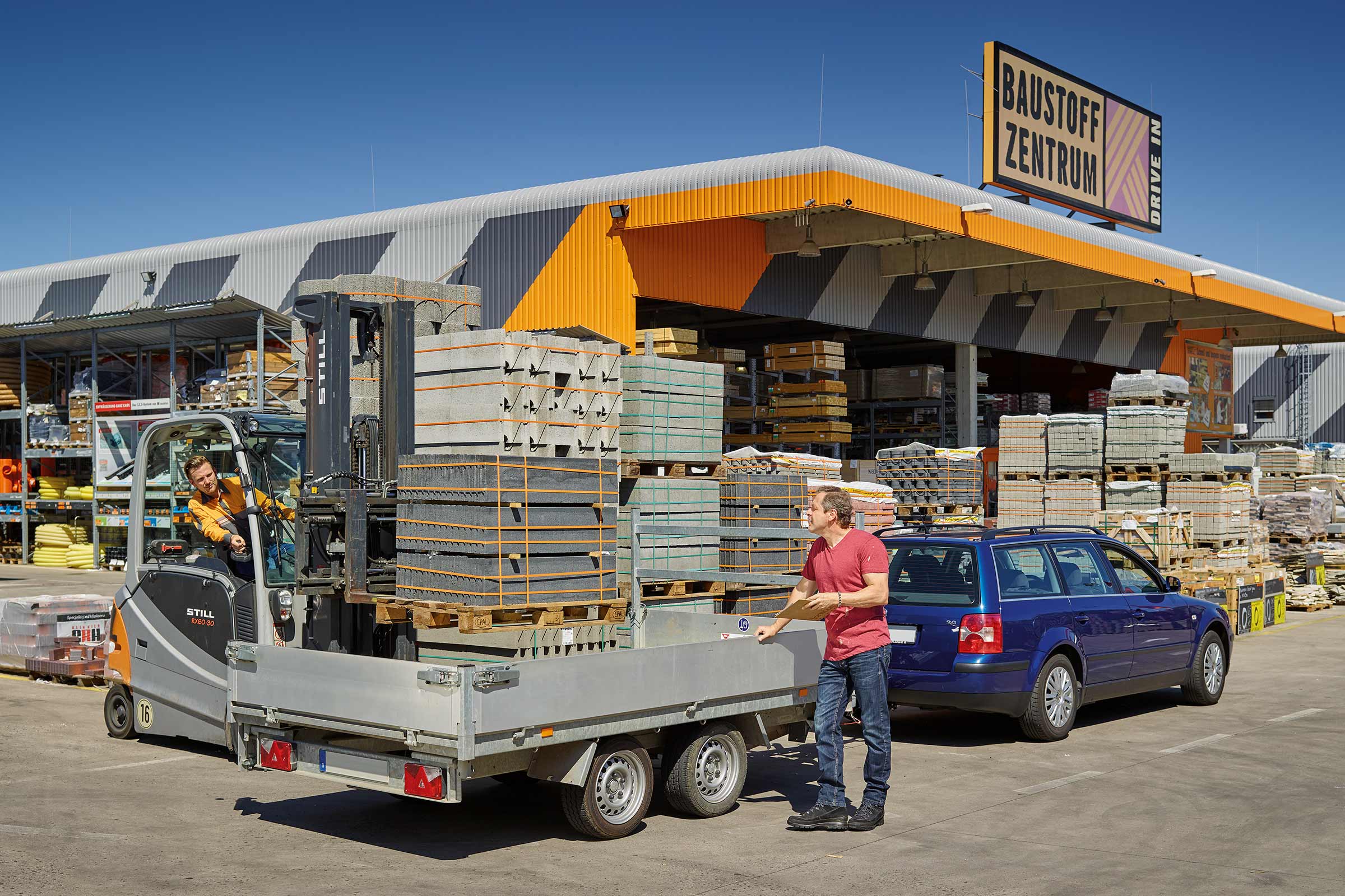Un homme charge des pavés sur une remorque devant le centre de matériaux de construction Hornbach.