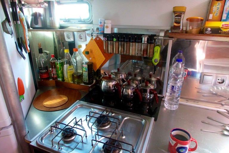 Scène de cuisine avec plaque de cuisson, évier et divers ustensiles de cuisine