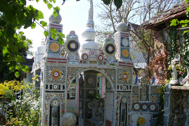 Vue détaillée d'une construction de jardin artistique, ornée de céramiques et de mosaïques.