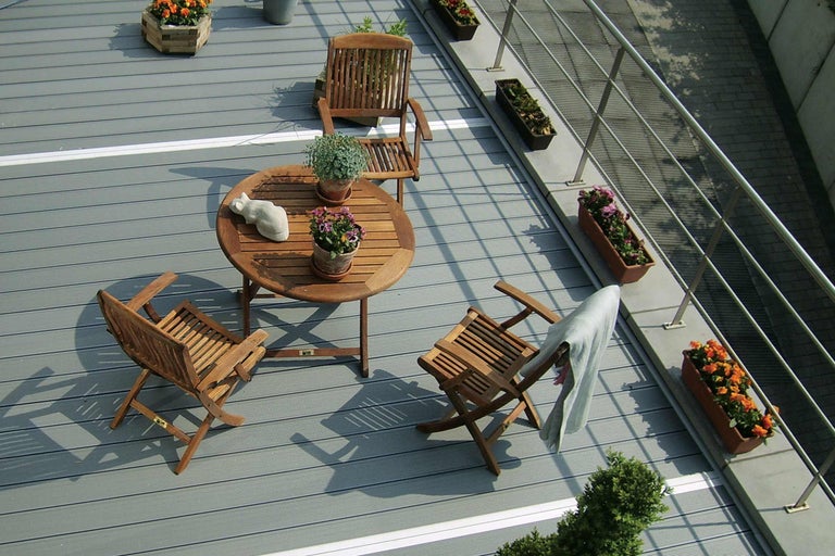 Terrasse avec sol en bois, table en bois et chaises en bois