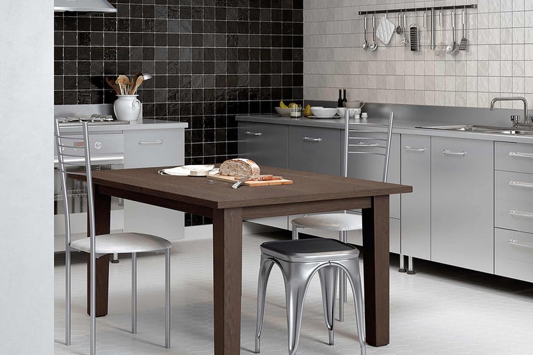 Küchenszene mit Esstisch, Stühlen, Küchenutensilien und Fliesen