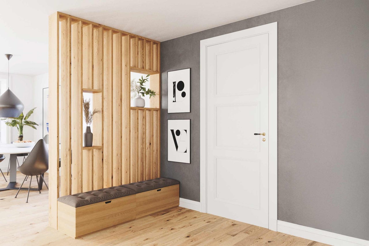 Entrée lumineuse avec lambris en bois, banc et porte blanche