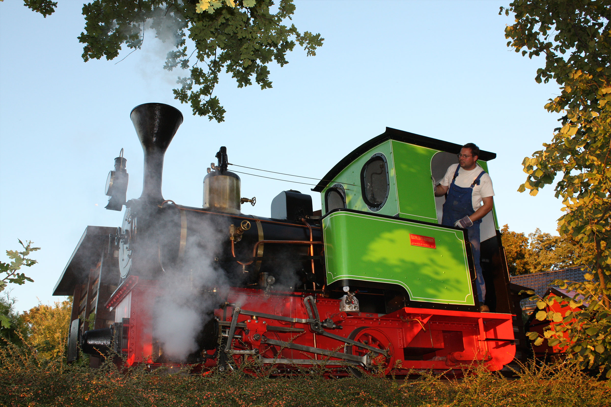 Une locomotive à vapeur avec un homme dans la cabine.