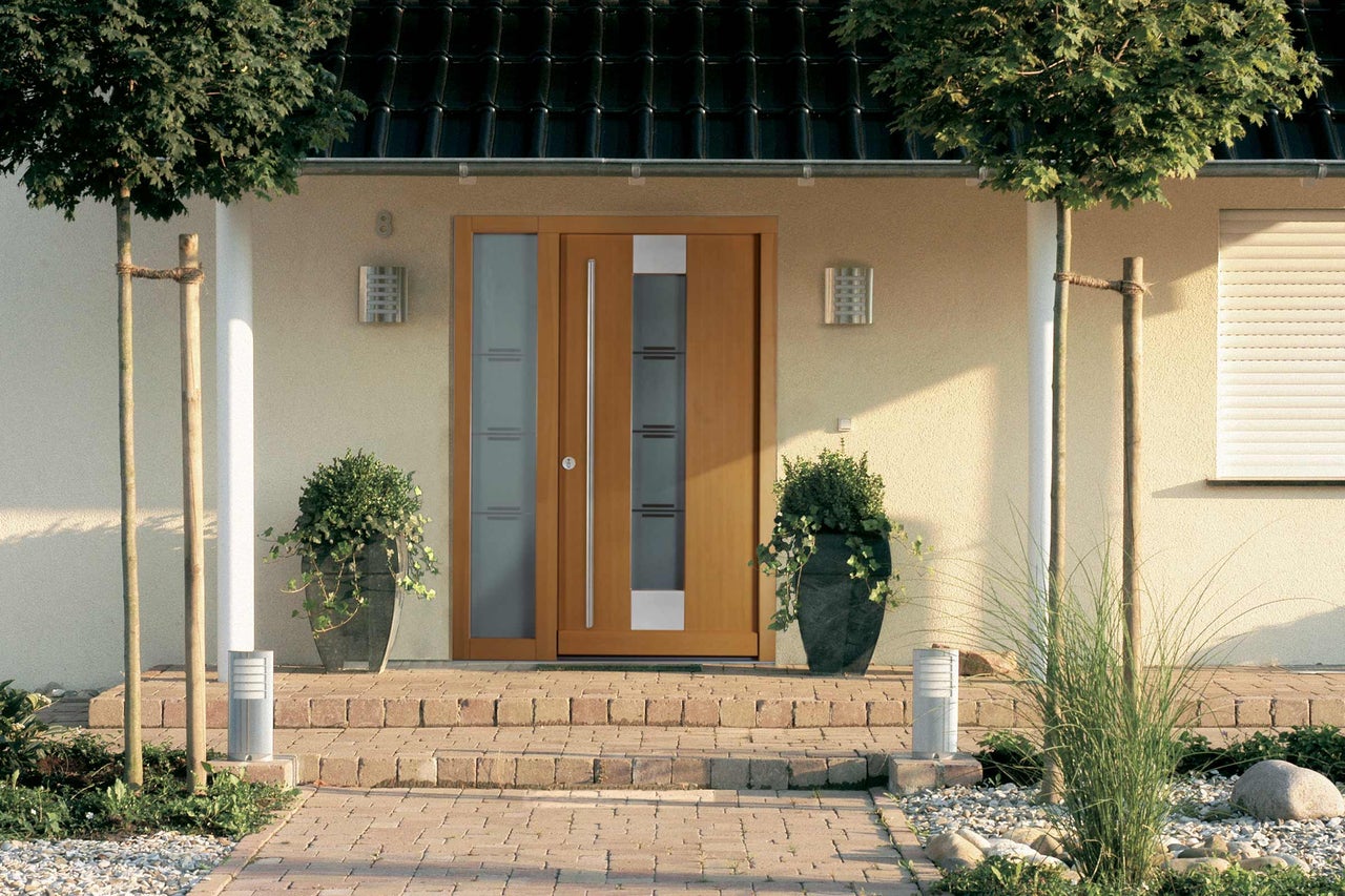 Zone d'entrée d'une maison avec porte d'entrée et pots de fleurs