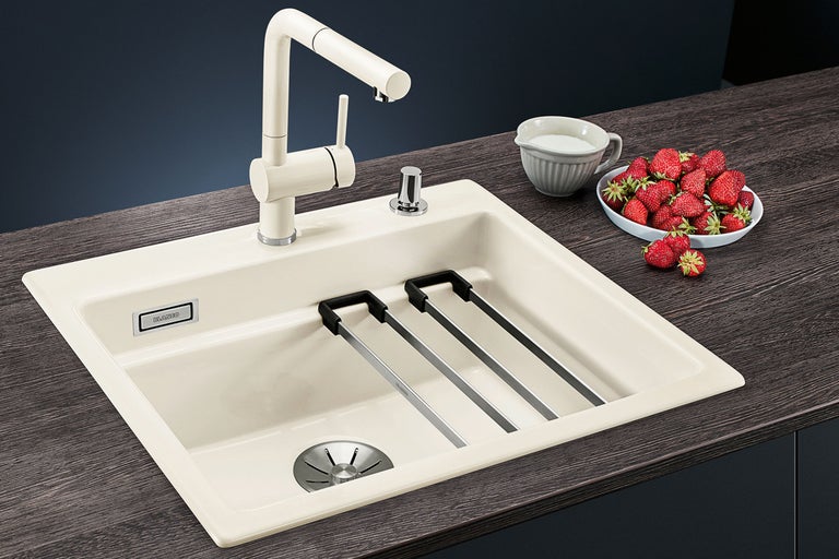 Évier avec égouttoir, robinet, lait et fraises sur un comptoir de cuisine