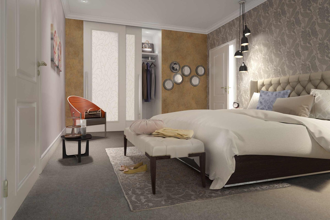 Ein Schlafzimmer mit einem Bett, einem Sessel und einem Kleiderschrank.