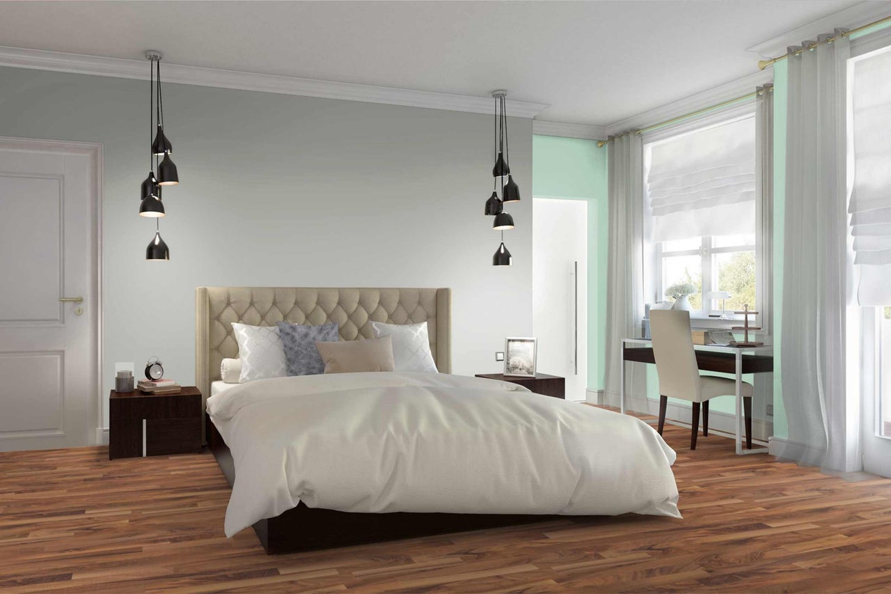 Une chambre lumineuse avec un lit double, des tables de chevet et un espace de travail près de la fenêtre.