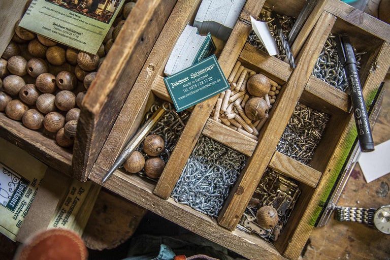 Holzkiste gefüllt mit Holzkugeln, Dübeln und Schrauben