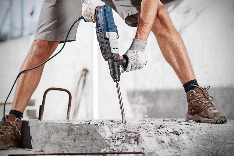 Un homme travaille le béton avec un perforateur Bosch.