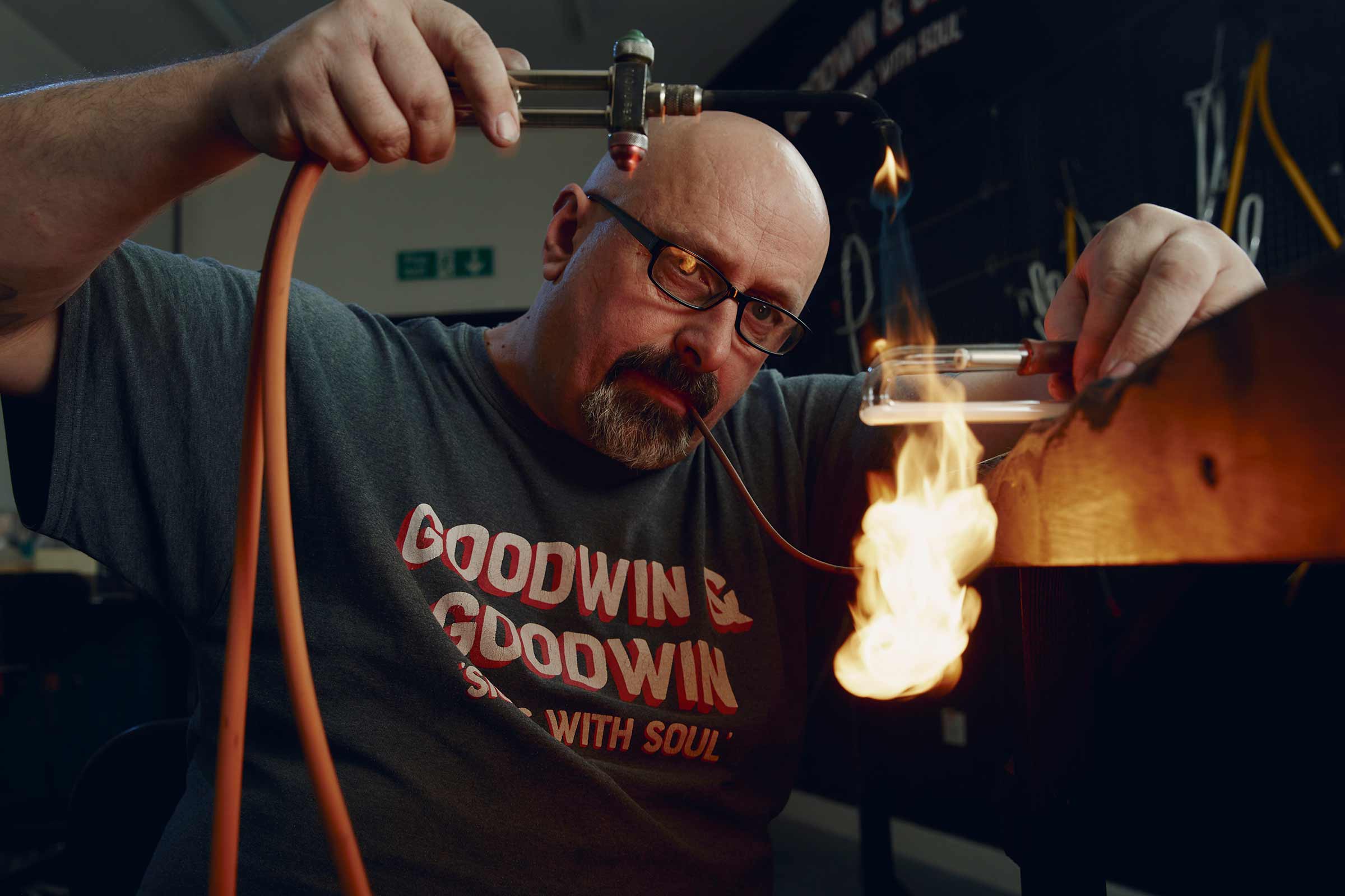 Un homme façonne le verre avec un brûleur