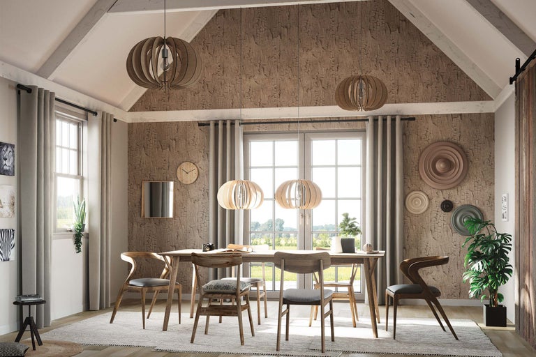 Salle à manger avec table à manger, chaises et suspensions dans une pièce lumineuse.