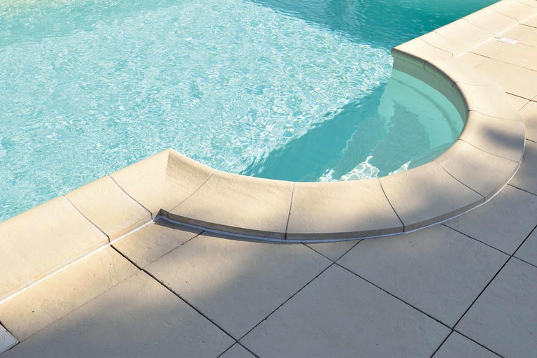 Vue détaillée d'une piscine avec margelles et carrelage