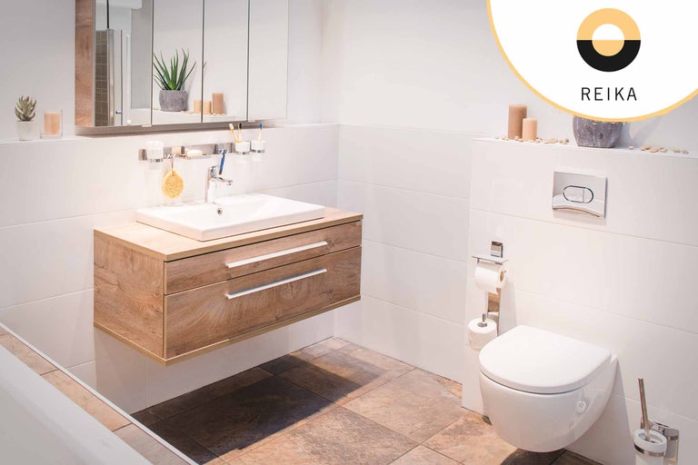 Salle de bain lumineuse avec meuble sous-lavabo en bois, toilettes et miroir