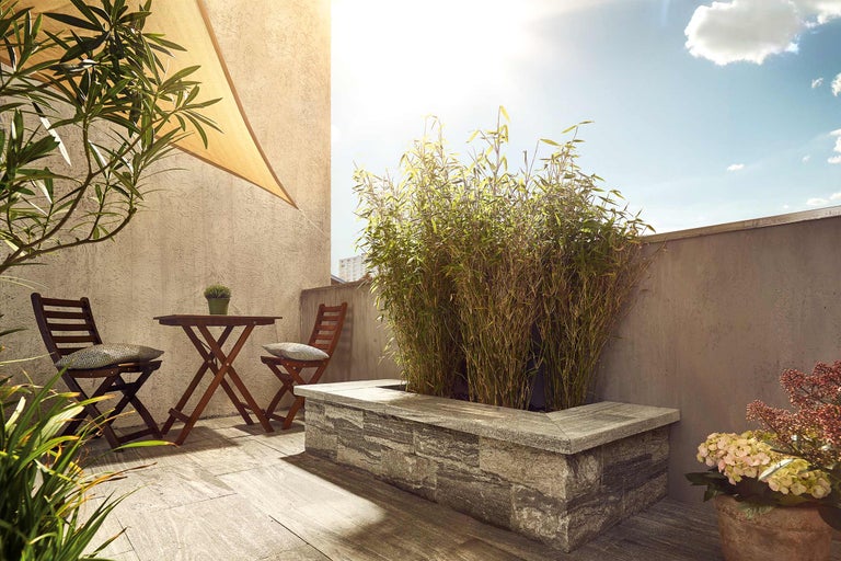 Terrasse avec plancher en bois, table en bois avec deux chaises, bambou et voile d'ombrage