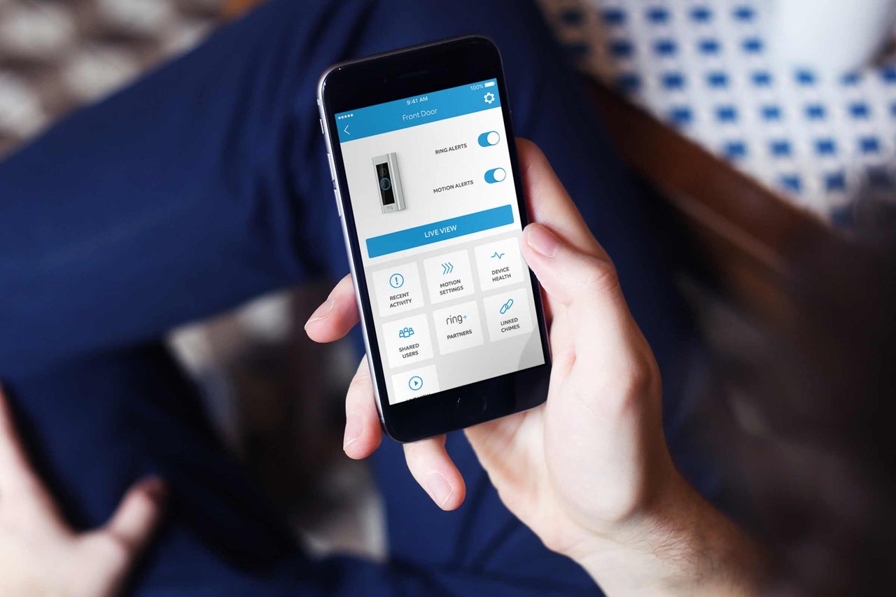 Eine Person hält ein Smartphone mit der geöffneten Ring App.