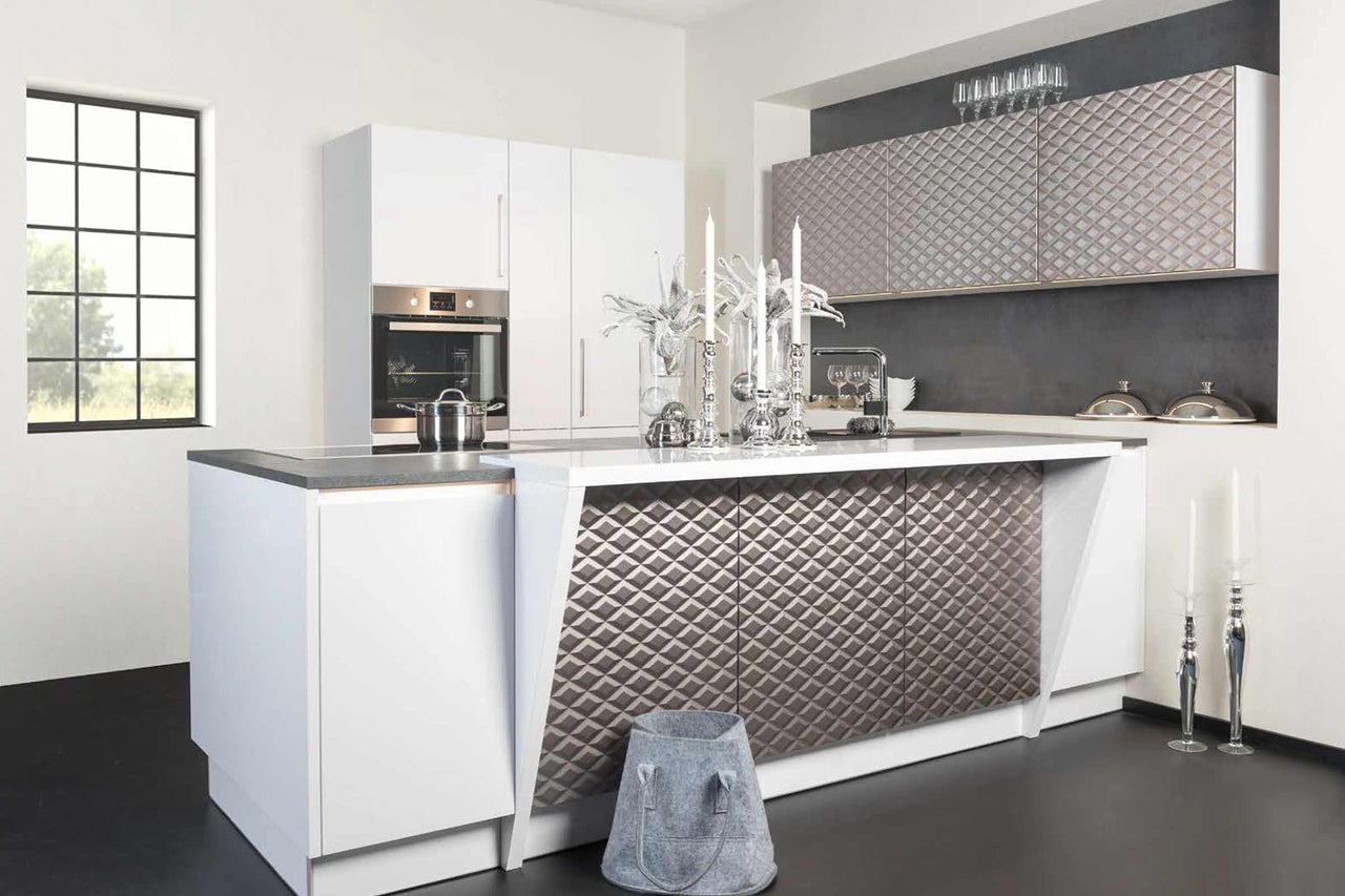 Cuisine claire avec îlot de cuisine, four encastrable et surfaces structurées