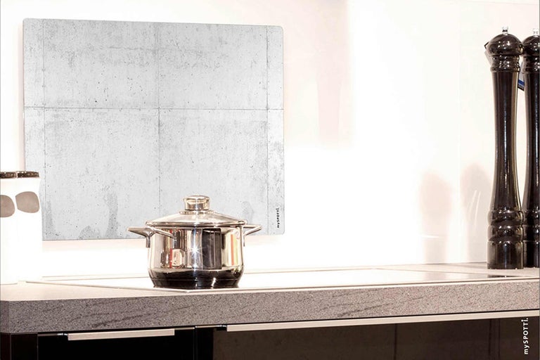 Scène de cuisine avec protection anti-éclaboussures aspect béton, casserole et moulins à épices