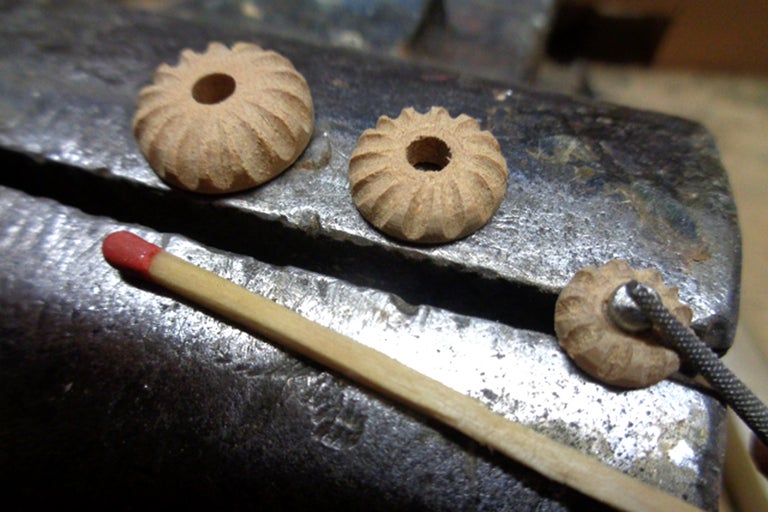 Trois perles décoratives en bois avec trou et une allumette