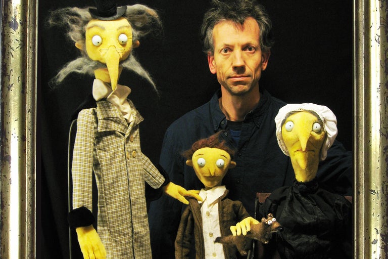 Homme avec des marionnettes dans un cadre doré