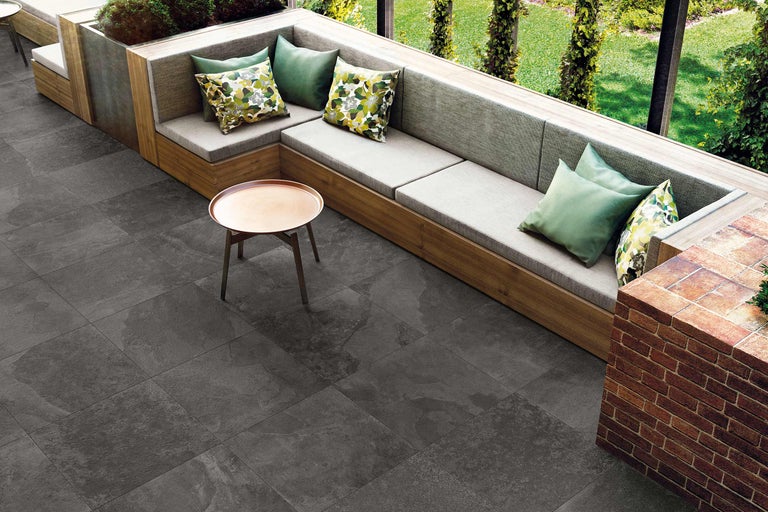 Espace extérieur avec sol carrelé, sièges et table