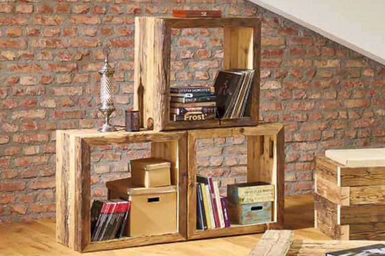 Étagères en bois empilées avec des livres et des objets décoratifs devant un mur de briques.