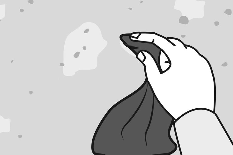 Une main essuie une surface irrégulière avec un chiffon.