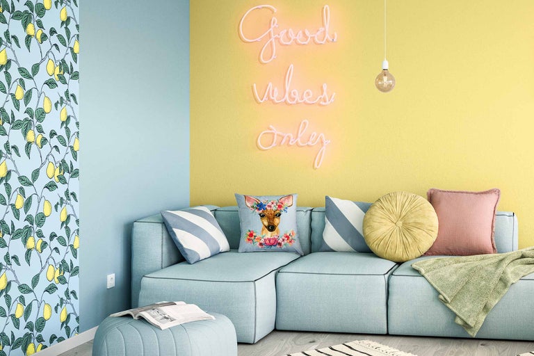 Helles Wohnzimmer mit türkisfarbenem Ecksofa, Kissen, Neon Schriftzug und Zitronen Tapete