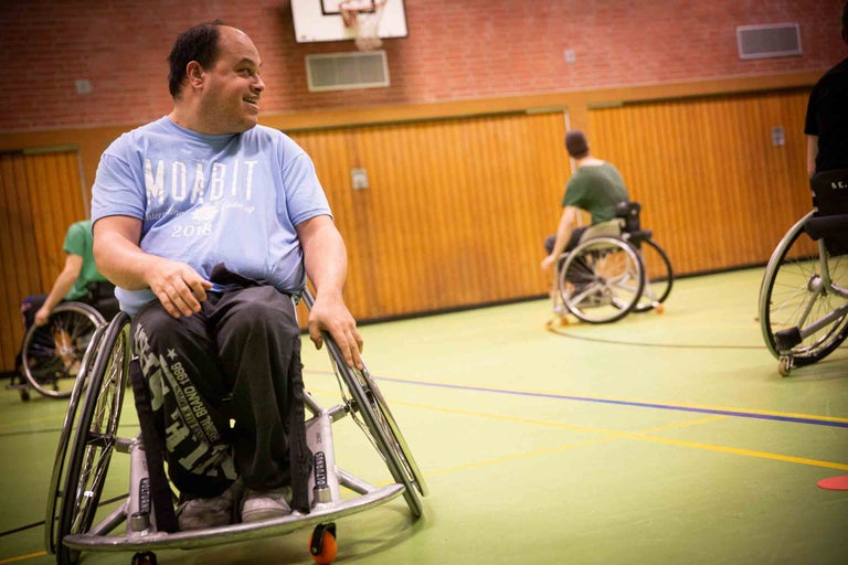 Rollstuhlfahrer in einer Turnhalle beim Sport
