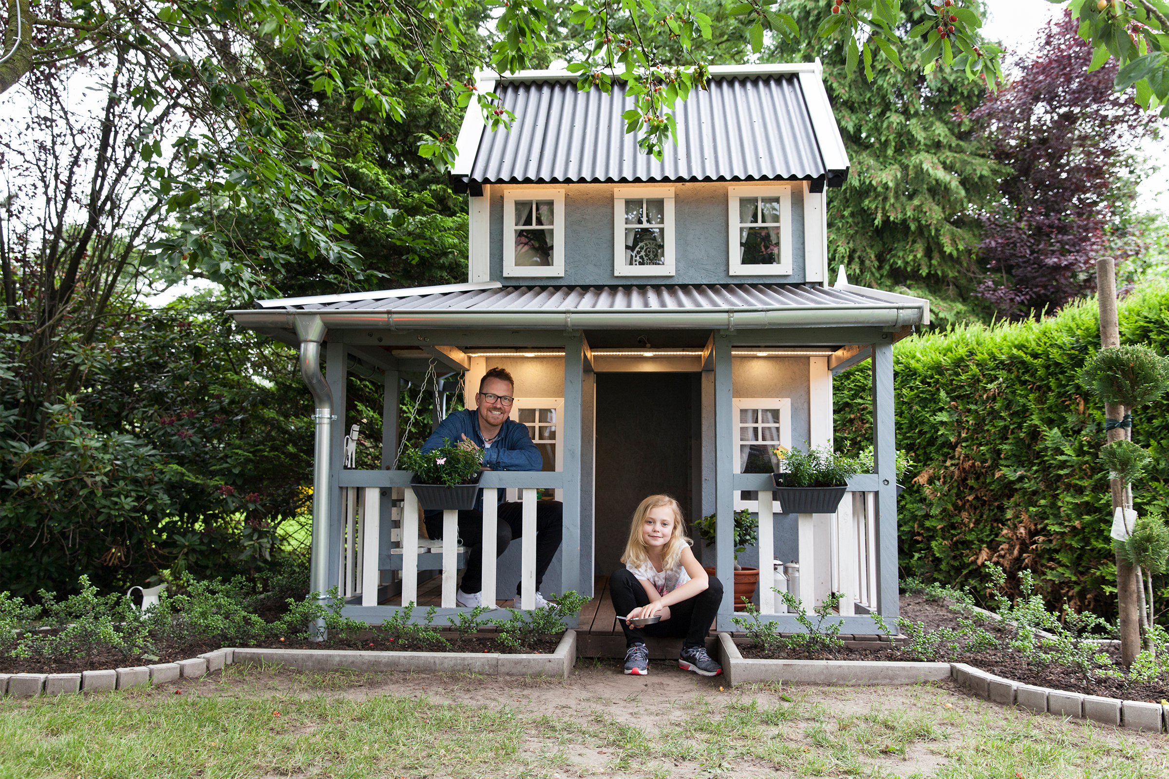 Spielhaus im Garten mit Mann und Mädchen
