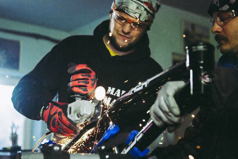 Mann schneidet Metall mit einem Winkelschleifer, Funken fliegen