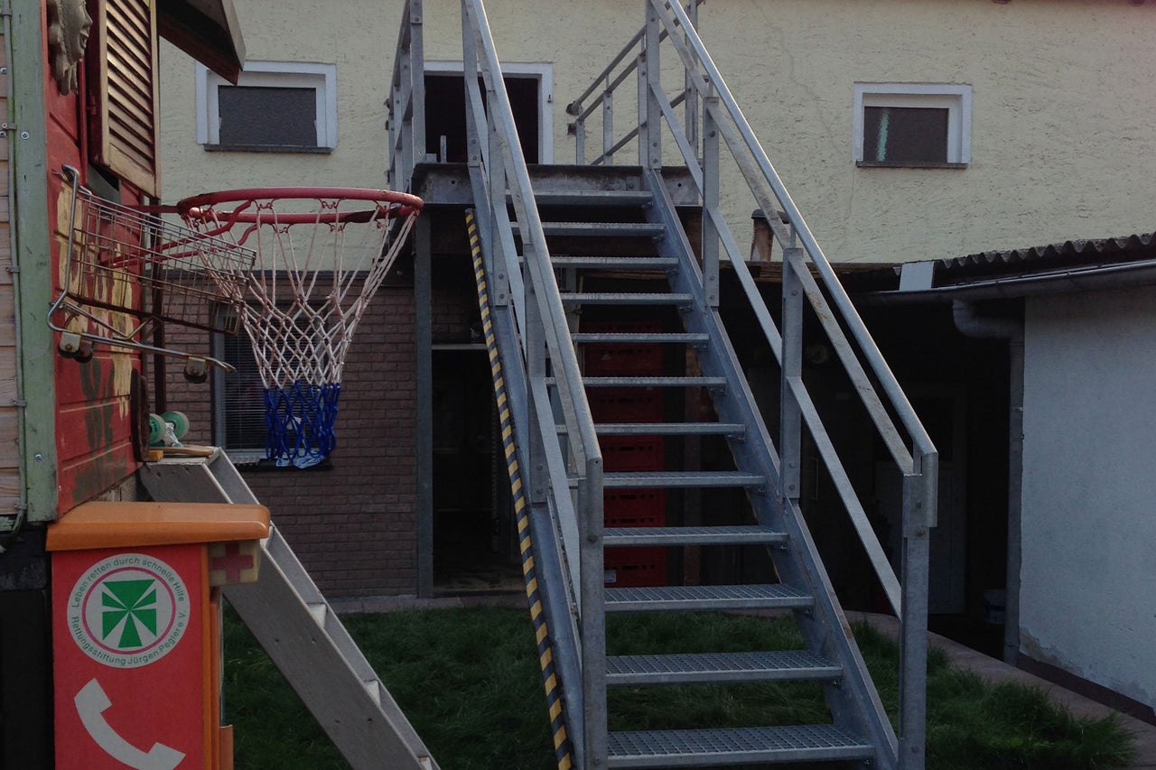 Vue extérieure d'un bâtiment avec escalier et panier de basket-ball