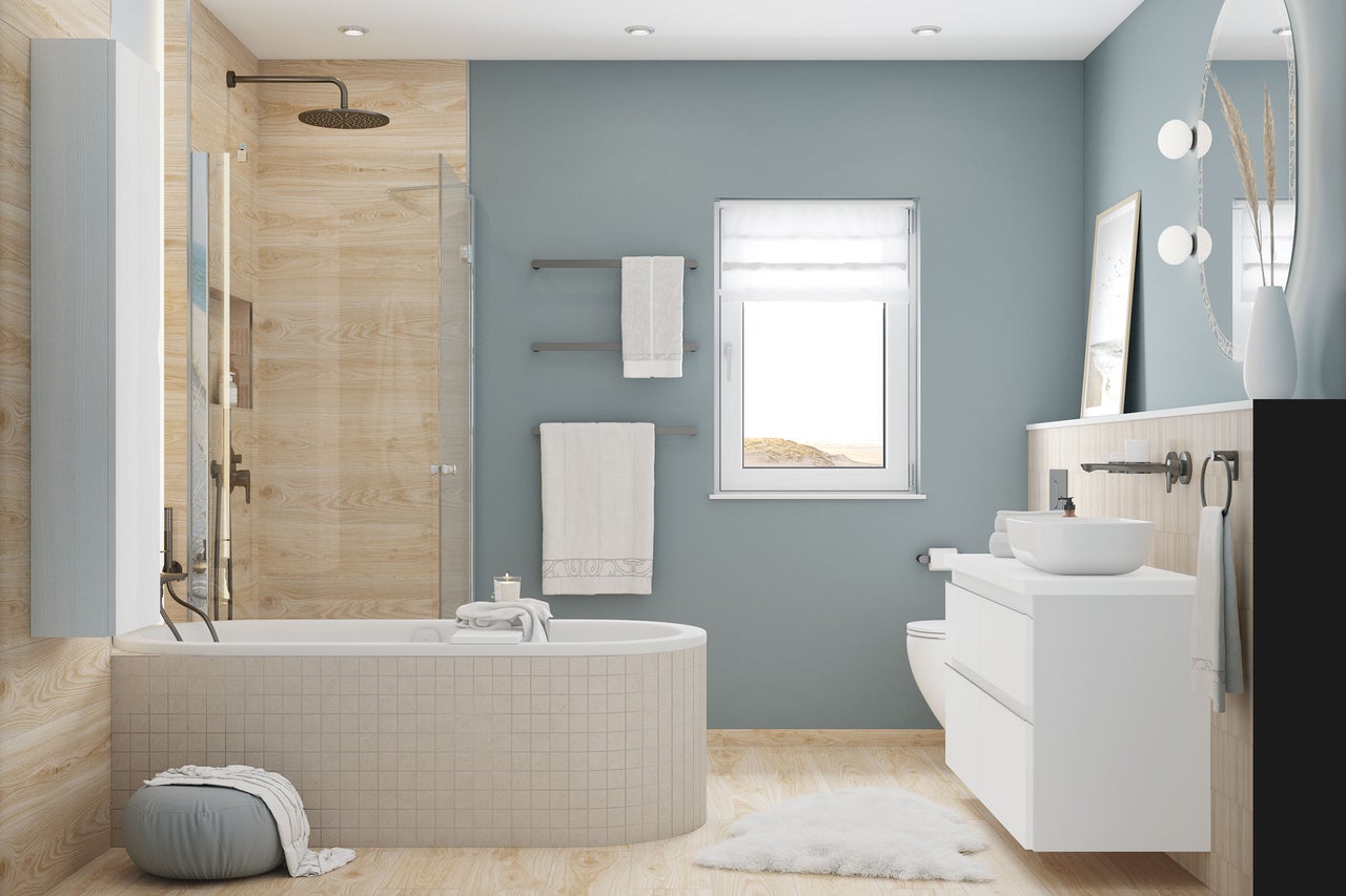 Salle de bain moderne avec baignoire, douche, meuble sous vasque blanc et carrelage mural aspect bois clair.