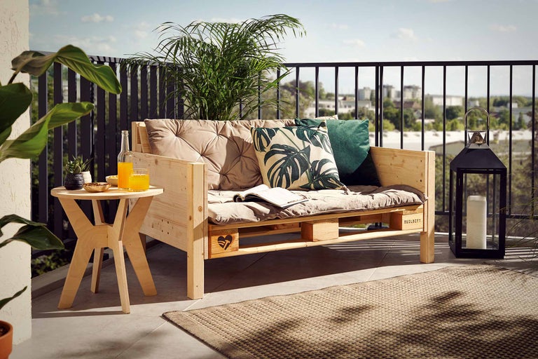 Ensemble de mobilier de balcon avec canapé en palette de bois, table d'appoint et lanterne sur un balcon