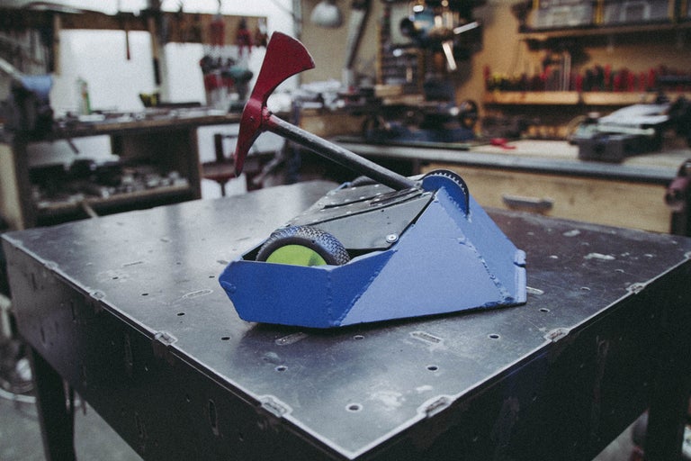 Gros plan d'un robot de combat avec une hache sur une table en métal