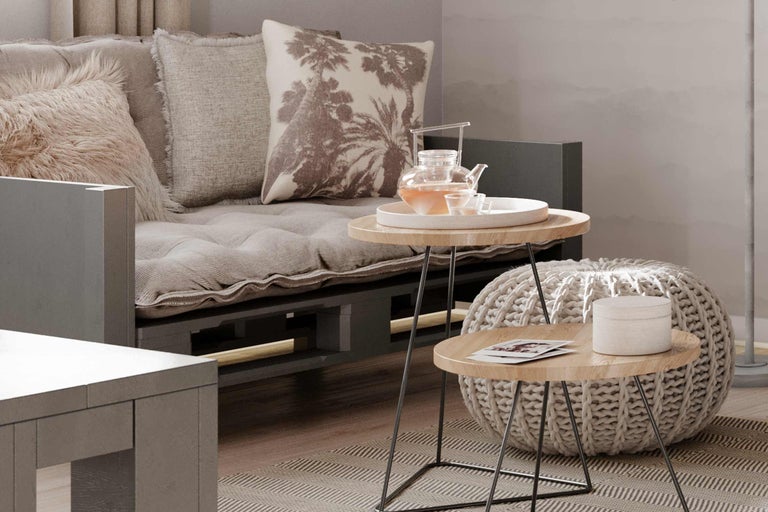 Wohnzimmer mit Palettensofa, Kissen, Beistelltischen und Sitzpuff