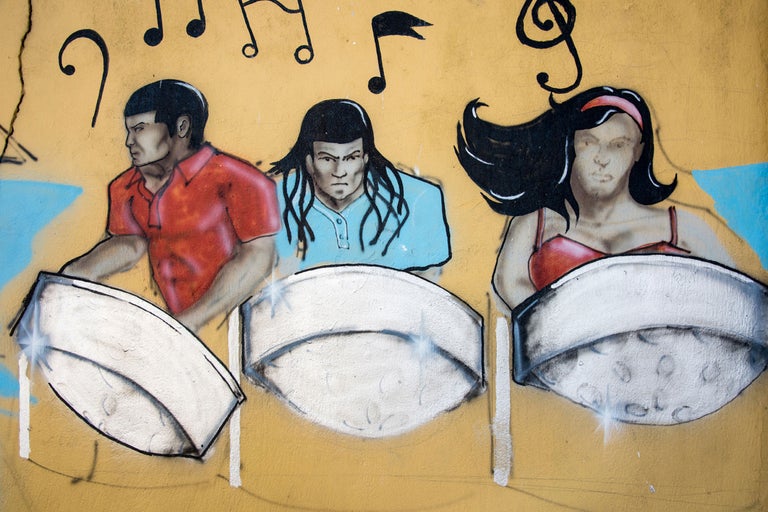Peinture murale représentant trois personnes jouant des percussions, entourées de notes de musique.