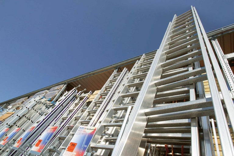 Plusieurs échelles en aluminium de différentes tailles sous un ciel bleu