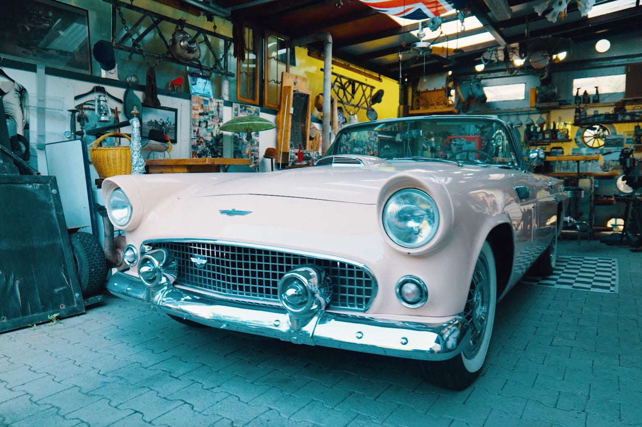 Voiture de collection dans un garage avec diverses décorations