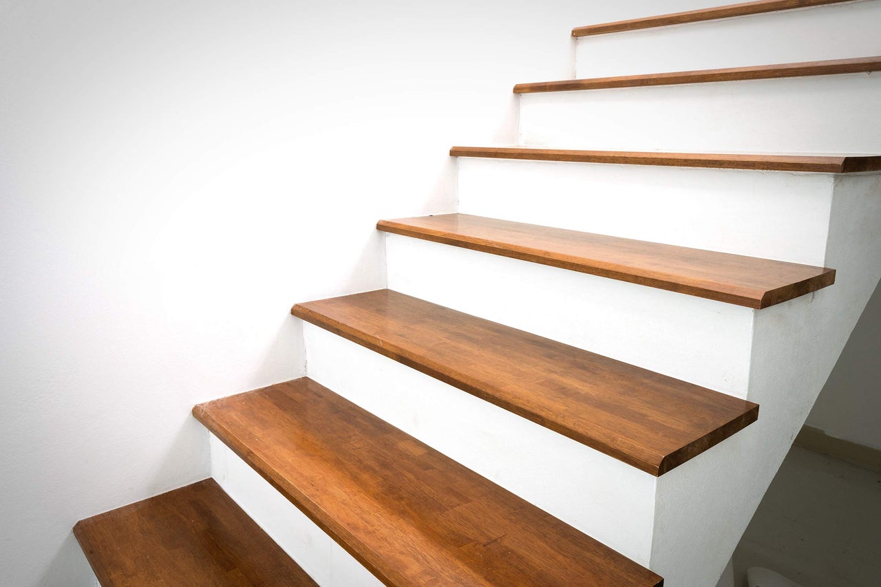Escalier avec marches en bois et cage d'escalier blanche