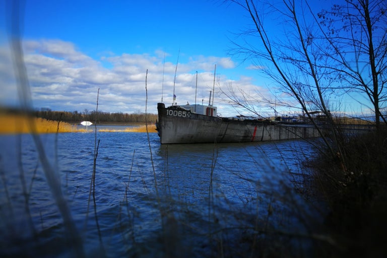Un bateau repose dans l'eau sous un ciel bleu.