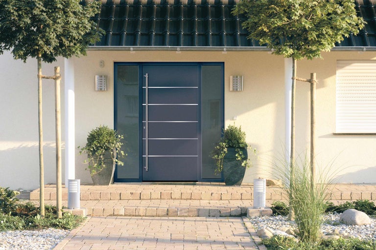 Zone d'entrée d'une maison avec porte d'entrée, éclairage et plantes
