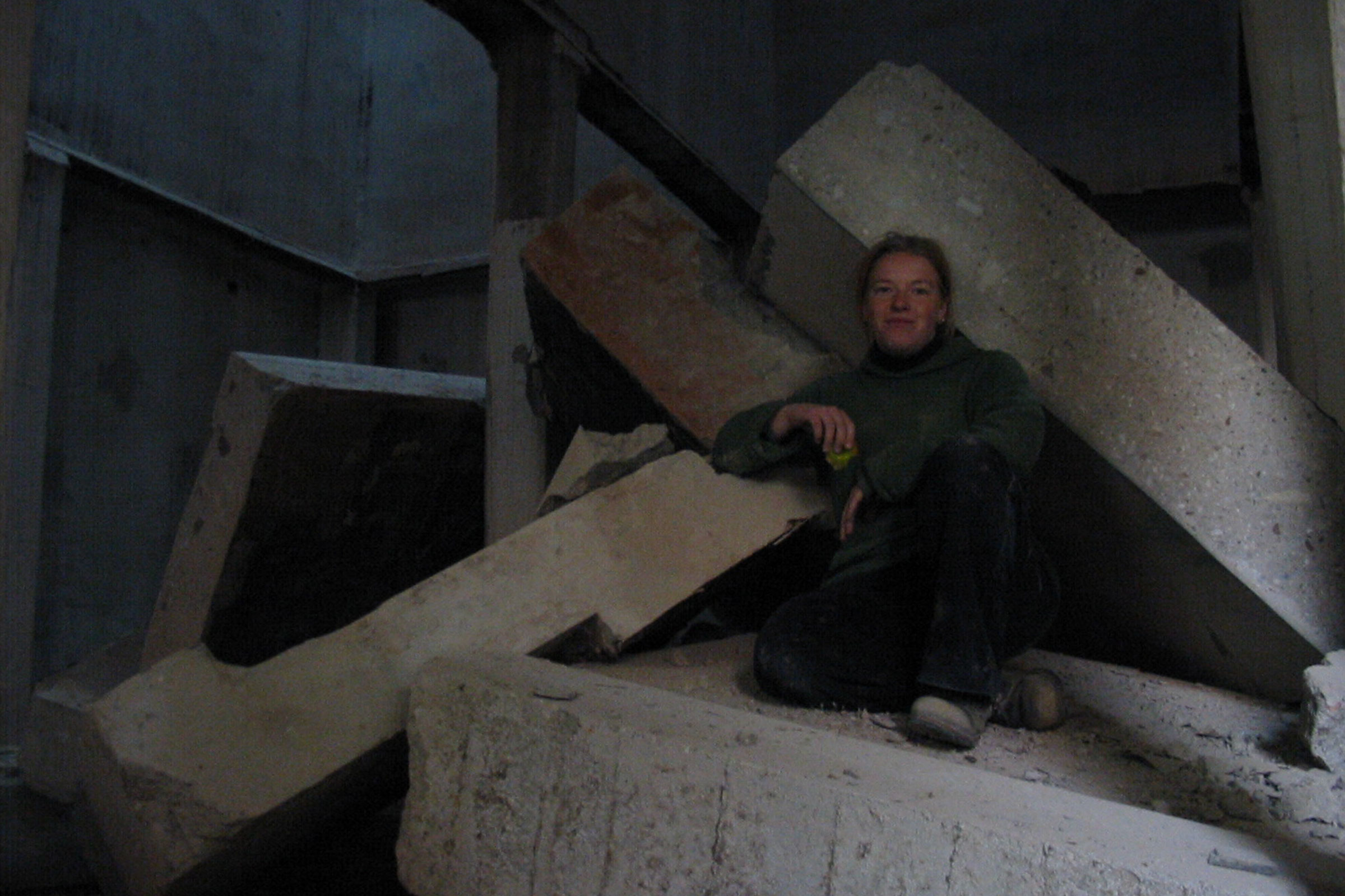 Femme assise sur des blocs de béton dans une construction brute