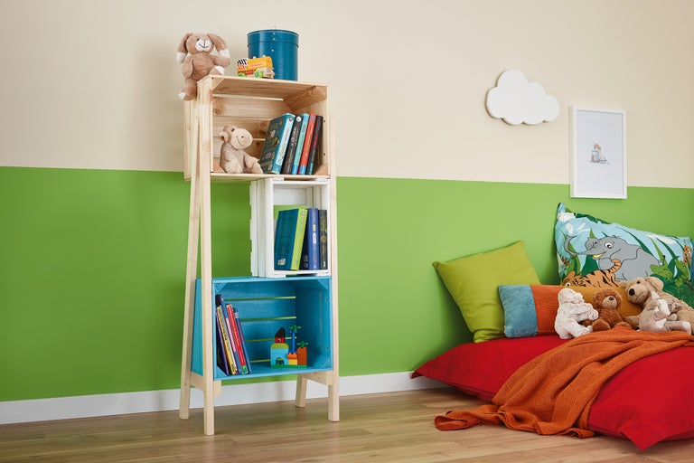 Salle de jeux pour enfants avec étagère en caisses de bois, jouets et coussins