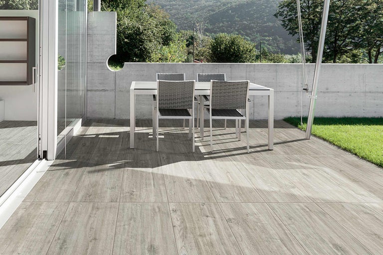 Terrasse avec planches en bois et groupe de tables de jardin