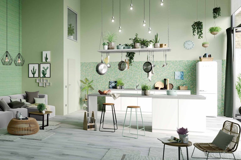 Helle, offene Wohnküche mit Kücheninsel, Kochutensilien und Sitzgelegenheiten für eine einladende Atmosphäre.