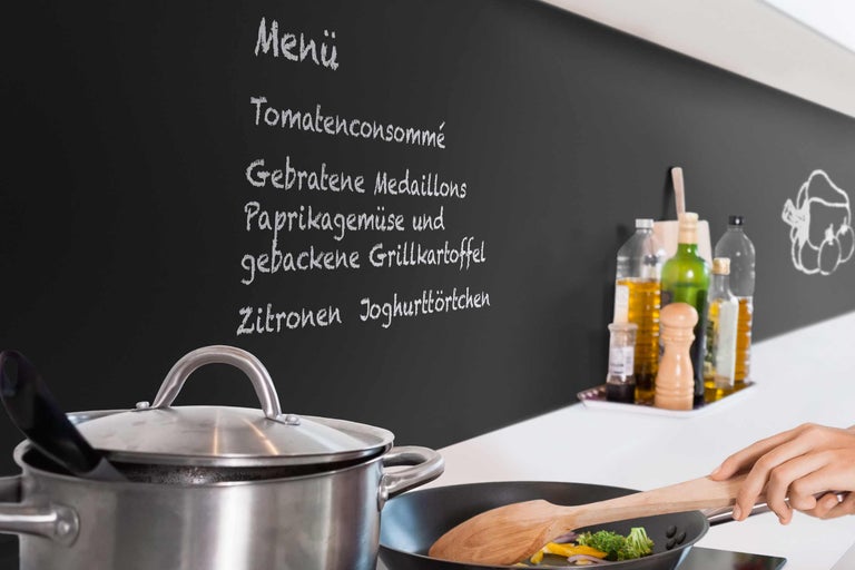 Scène de cuisine avec casserole, poêle à frire et tableau de menu écrit à la main